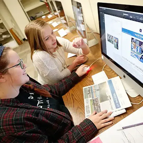 image of journalism students working at a computer